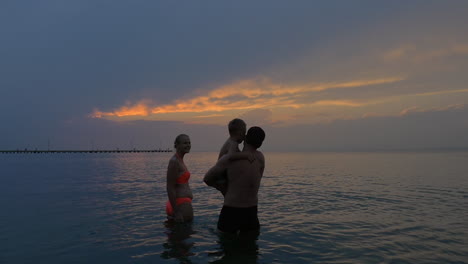 Family-with-child-in-the-sea-at-twilight