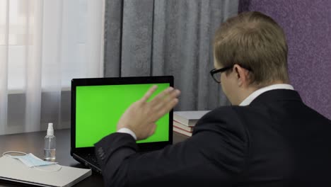 Man-have-video-call-conference-on-laptop-with-green-screen.-Distance-work-online