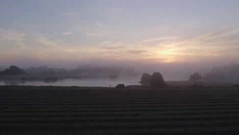 Rising-up-at-Bourtange-with-camper-van-parked-next-to-lake,-aerial