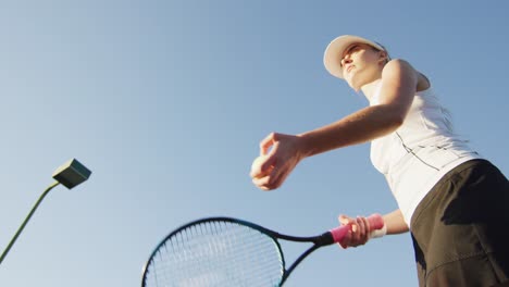 video of low angle of focused caucasian female tennis player holding racket and hitting ball