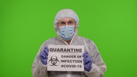 hombre con traje de protección que sostiene un cartel de cuarentena