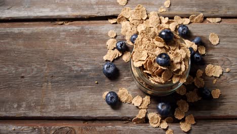 jar filled with wheat flakes and blueberries 4k