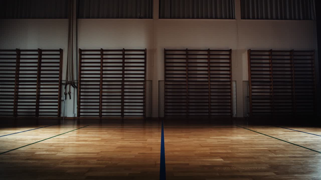 나무 바닥과 벽 바를 가진 빈 체육관