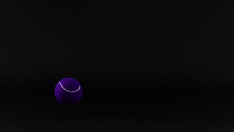 una pelota de tenis púrpura se mueve contra la oscuridad
