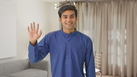 indian man waving hand and saying hello