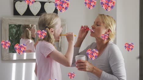 Animation-of-flowers-over-caucasian-mother-and-daughter-brushing-teeth