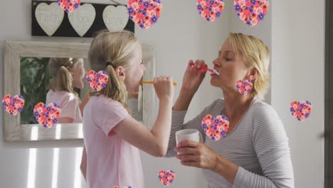 animation von blumen über kaukasische mutter und tochter, die zähne putzen