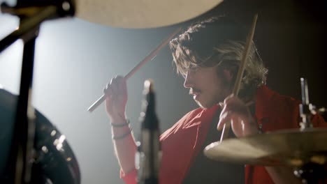 young male drummer playing drums at music studio