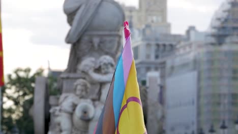 diverse pride flags displayed in an urban setting with a person in the foreground.