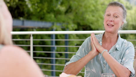 senior caucasian woman gestures during a conversation outdoors