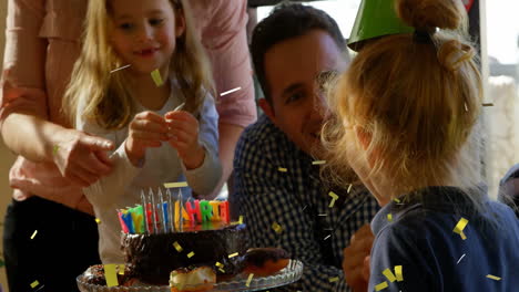 confetti animation over children celebrating birthday with cake and candles