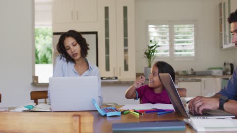 Hispanische-Mutter-Sitzt-Am-Tisch-Und-Arbeitet-Mit-Laptop,-Telefoniert-Und-Tochter-Zeichnet