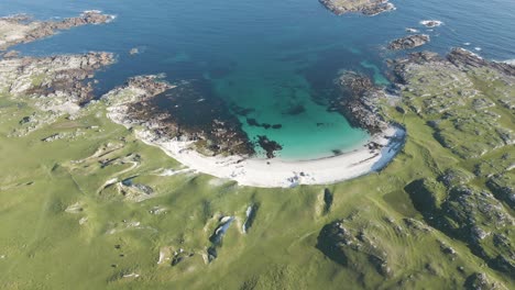 dog's bay beach surrounded by green rocky fields at daytime in connemara, ireland during summer