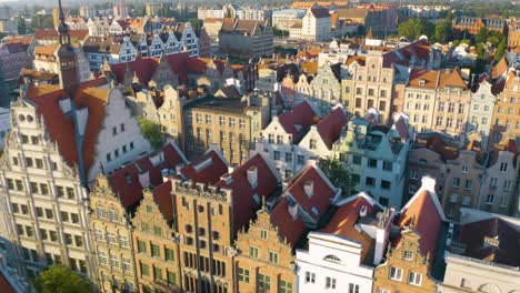 Vuelo-Aéreo-Bajo-Sobre-Coloridos-Edificios-De-Apartamentos-En-Gdansk,-Polonia-A-La-Hora-Dorada