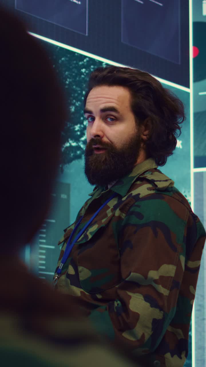 Bearded Man in Camouflage Jacket Observing Digital Screens