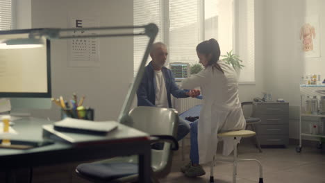 el médico comprueba el pulso del paciente anciano en el hospital.