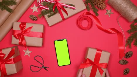 manos atando arco rojo en la caja de regalos de navidad