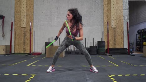 static wide angle, slow motion shot, one light, deep focus of a pretty hispanic female fitness model working out wearing fitness attire