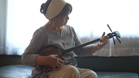 woman playing the sanshin