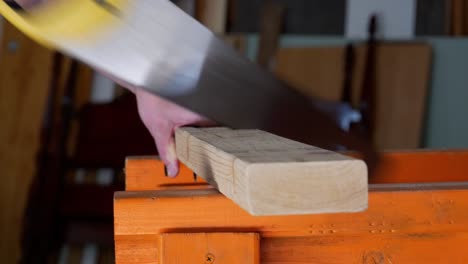 Nahaufnahme-Einer-Handsäge,-Die-In-Ein-Stück-2x4-Holz-Schneidet