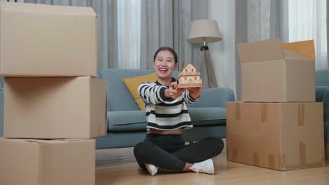 행복 한 여자 는 이동 중 에 모형 집 을 들고 있다