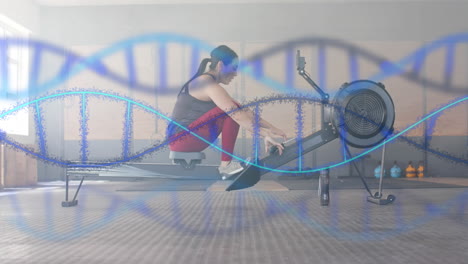 animation of dna strands over caucasian woman training on rowing machine at gym