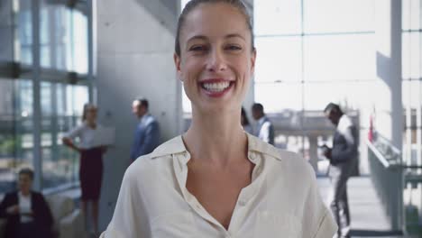 mujer de negocios mirando a la cámara en el vestíbulo de la oficina 4k