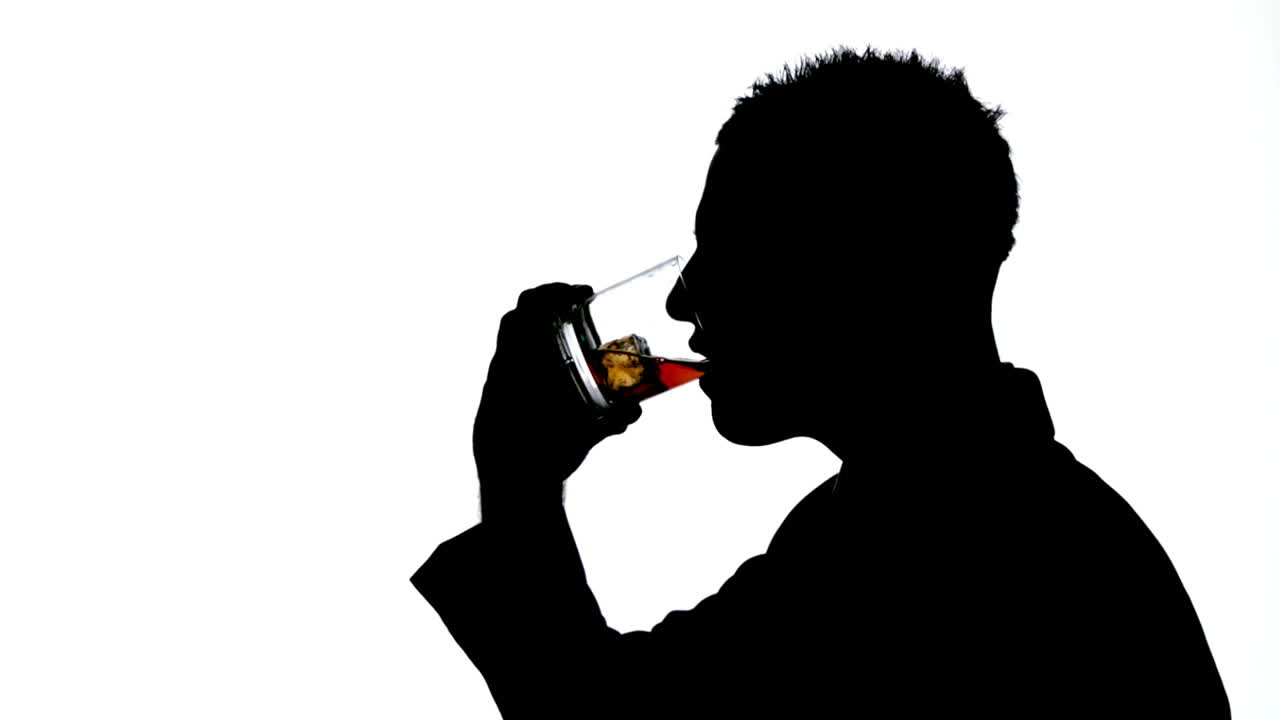 Silhouette of businessman drinking whiskey on white background