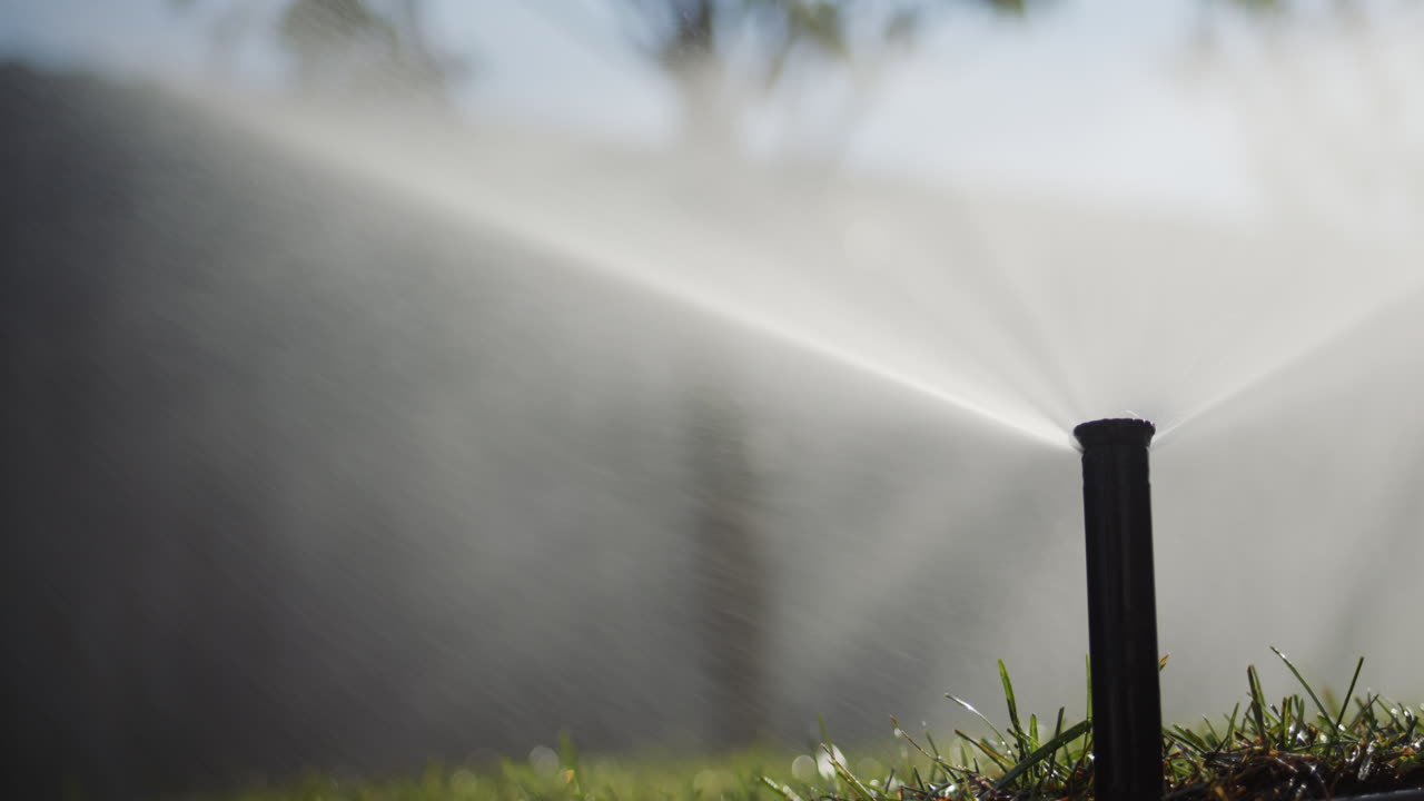 Sistema di irrigazione automatico che innaffia il giardino. Vista dal basso dell'ugello ad alta pressione.