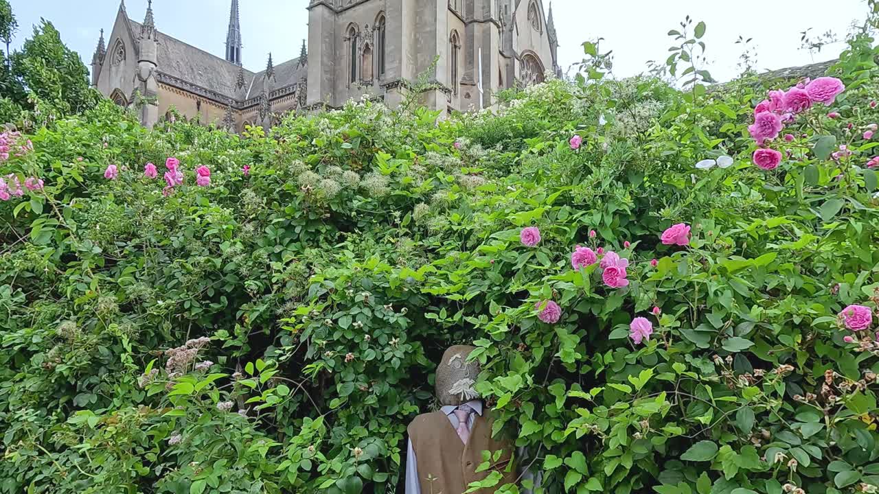 성 근처의 울창한 정원을 걸어가는 남자