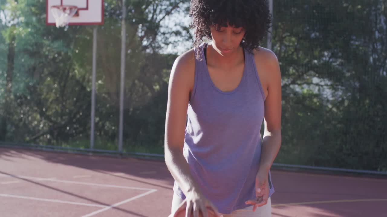 retrato de una jugadora de baloncesto afroamericana sosteniendo la pelota en una cancha soleada, en cámara lenta
