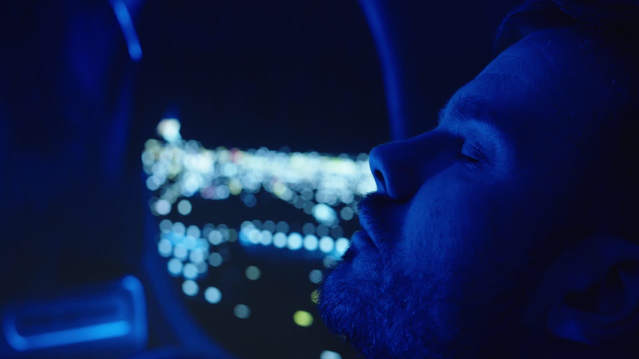 a man sleeping in an airplane in the background an airplane window