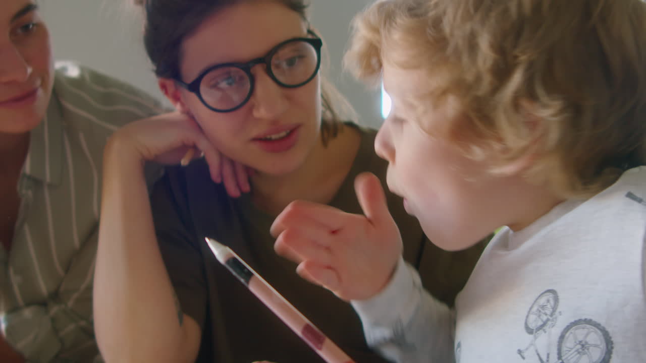 Little Boy Doing Homework with Help of Lesbian Mothers
