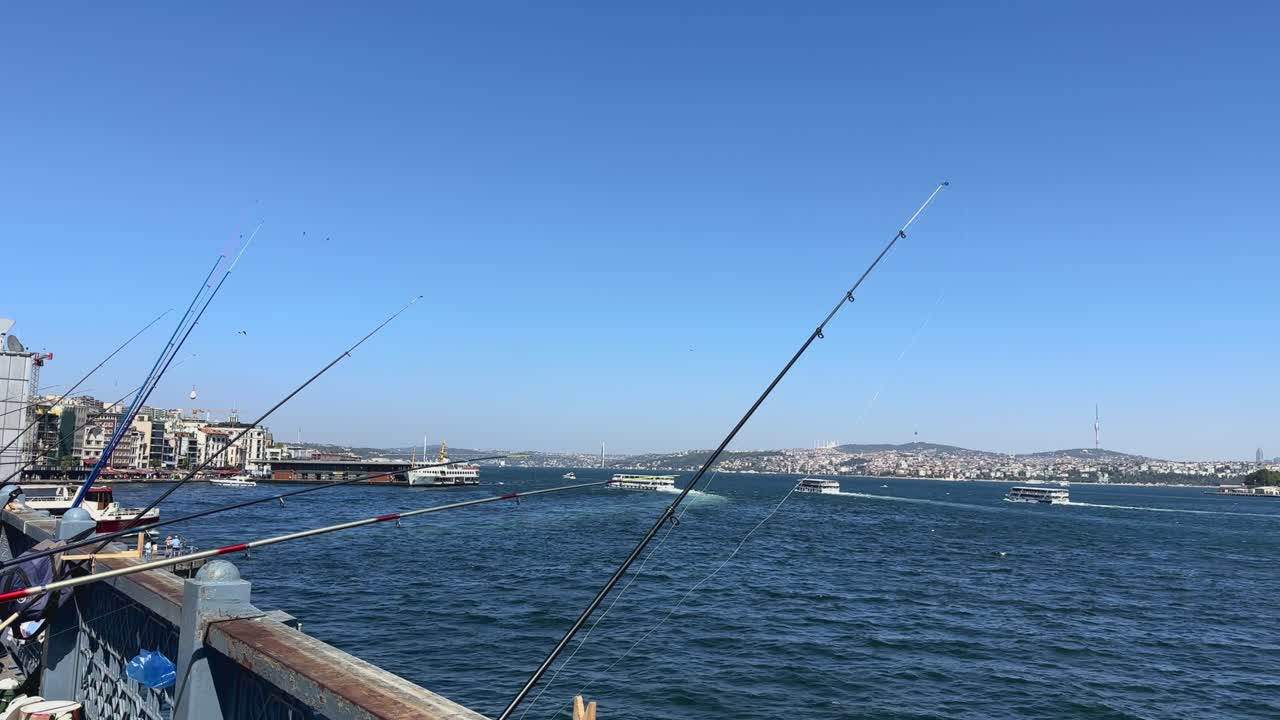Pescatori e canne da pesca sporgono da un ponte nel fiume alla periferia di Istanbul, Turchia
