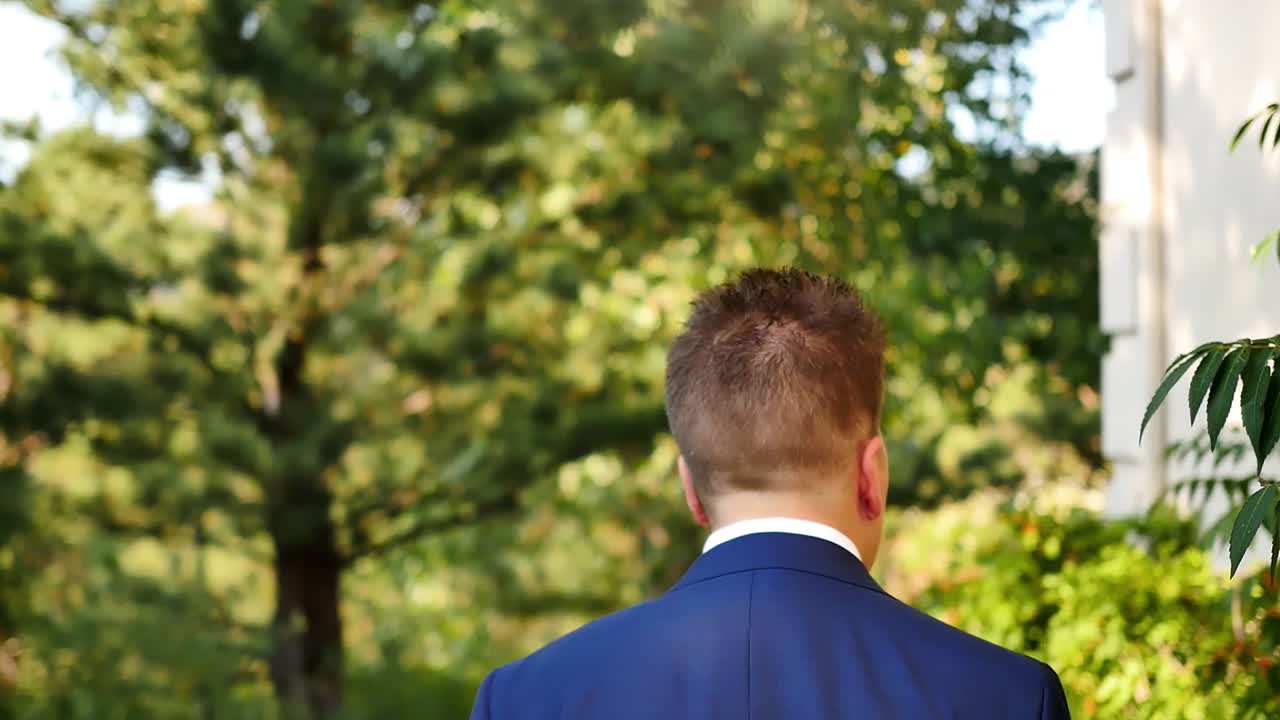 중성적인 퀴어가 뒤뜰에서 결혼하기 위해 큰 창문을 지나 맨션 옆을 돌아다닌다