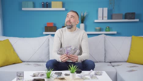 el hombre que gana dinero celebra en casa. le encanta el dinero.