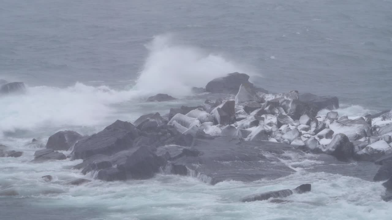 Rough Waves Crashing On The Rocks in Winter. - wide shot