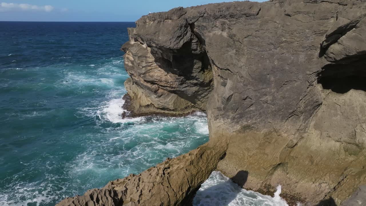 formación de orillas rocosas en la playa de arecibo, puerto rico, con olas golpeando las rocas.