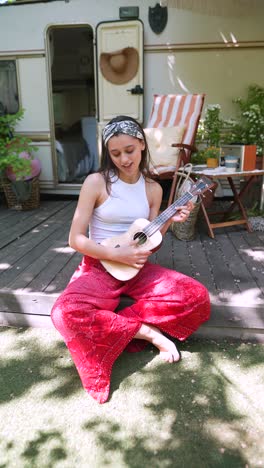 woman playing ukulele outdoors in a camper van