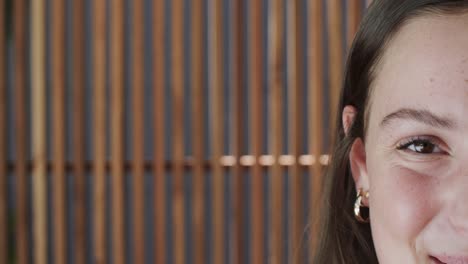 retrato de mitad de cara de una adolescente caucásica feliz con pecas sonriendo a la cámara en cámara lenta.