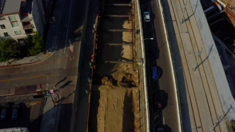 AERIAL:-Birds-Eye-View-of-Downtown-Los-Angeles-street-with-Cars,Traffic,Tram-and-tilt-up-to-skyline-at-beautiful-Daylight,