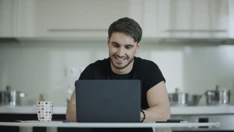 Hombre-De-Negocios-Trabajando-Con-Computadora-Portátil-Y-Bebiendo-Té-En-La-Cocina-De-Casa