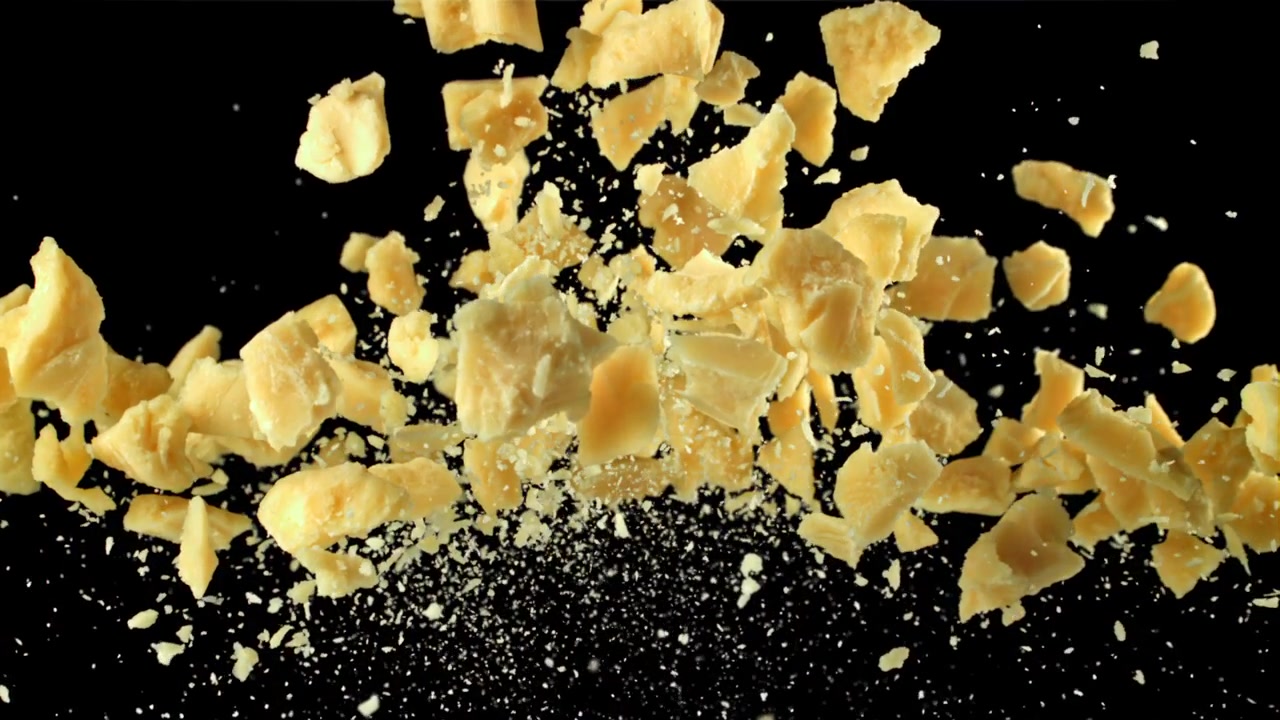 Slow Motion Parmesan Cheese Pieces Falling on Black Background