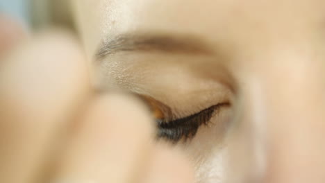 woman applying eyeshadow. make up artist applying liquid eyeliner on models eyes