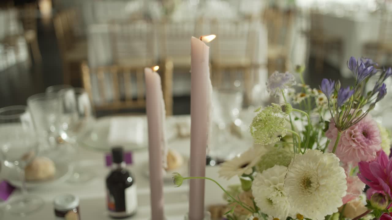 Романтический свадебный стол с горящими свечами и цветочной композицией