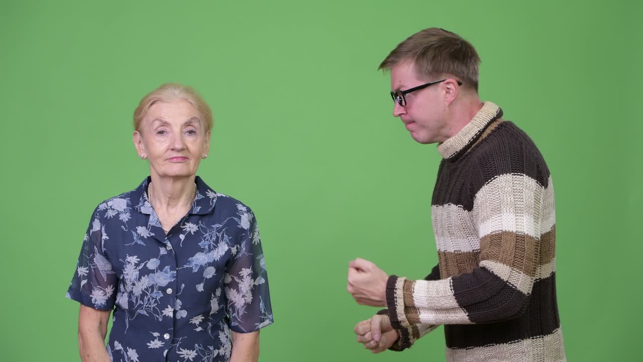 Angry grandson talking with unconcerned grandmother and shrugging