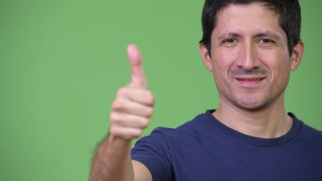 close-up of happy hispanic man giving thumbs up