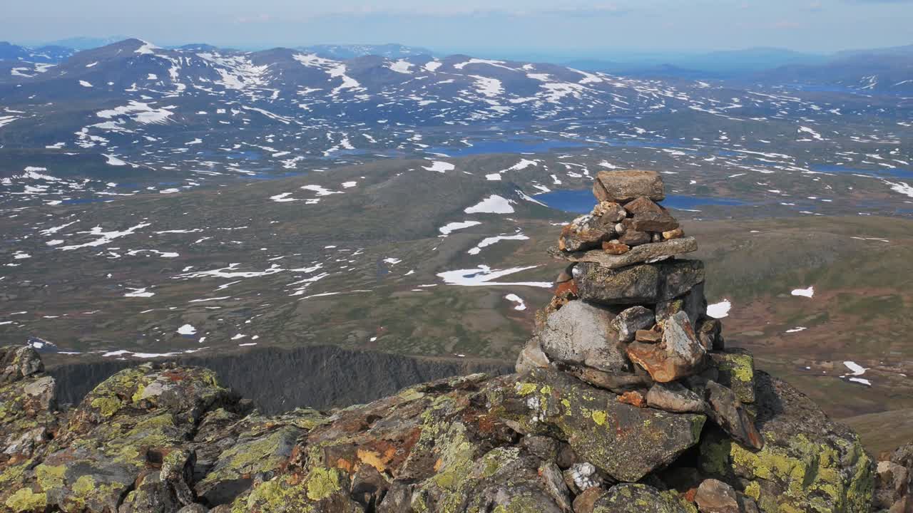 Pile Of Stones At The Snowy Landscape At Helagsfjallet In Sweden. wide shot