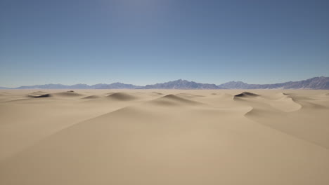 sand dunes in the desert with mountains in the background