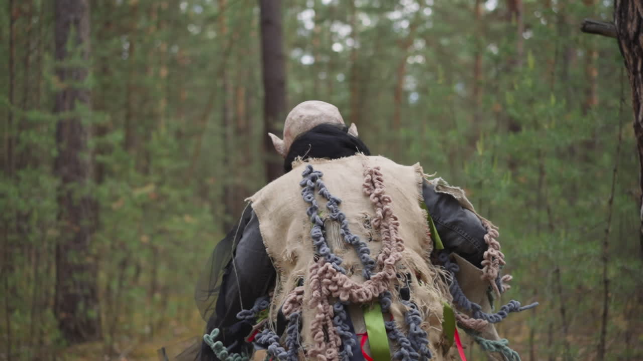 Person i monsterkostume løber væk i skoven